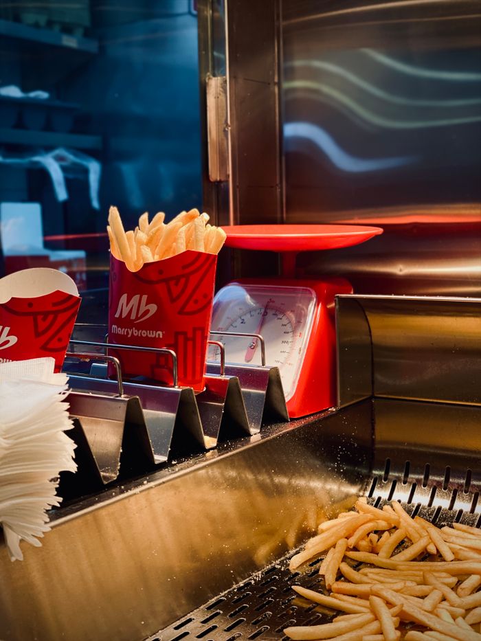 Tasty fast food French fries being prepared in a professional kitchen setting.